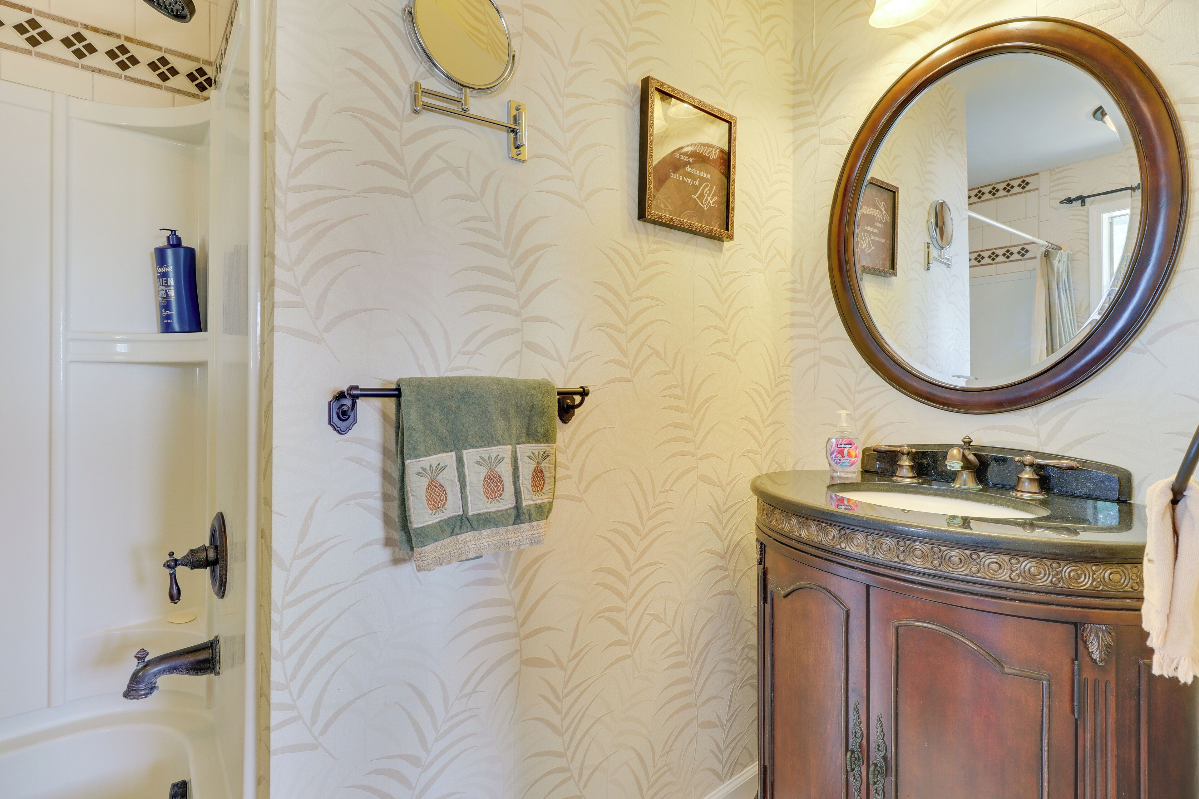 Une salle de bain avec une baignoire, un lavabo avec un meuble-vasque, un miroir et un porte-serviettes.