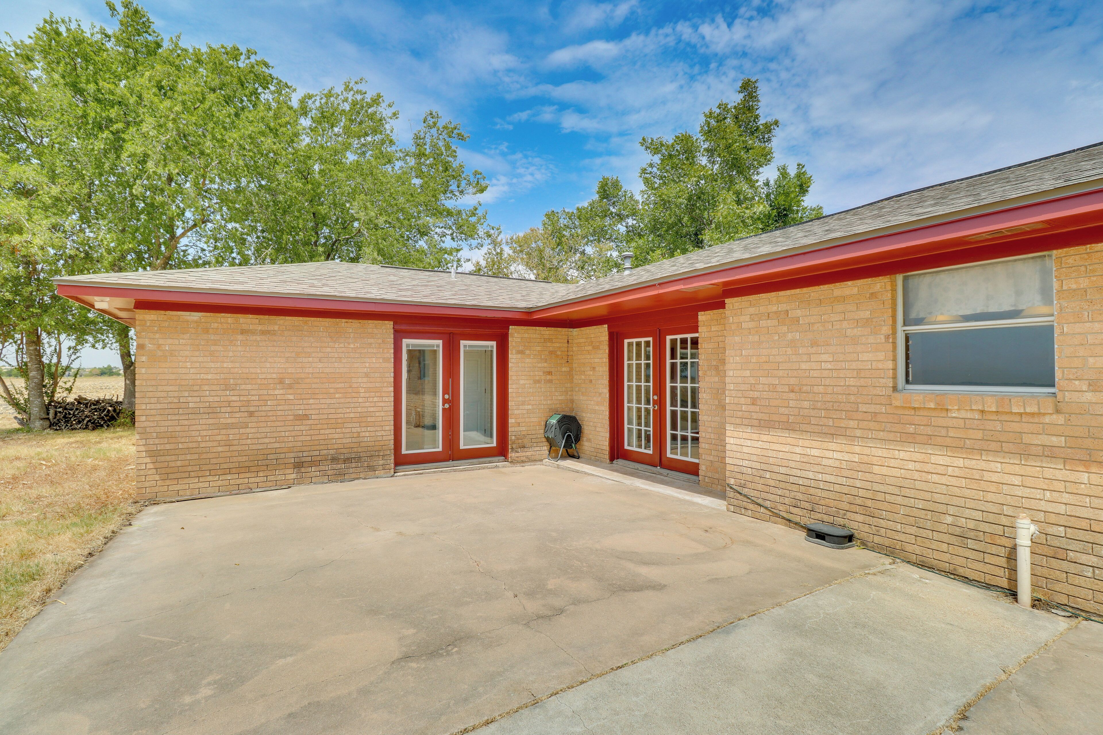 A single-story brick building with a red roof and a covered patio area.