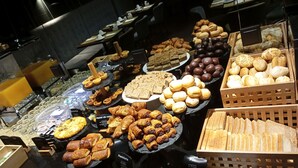 Un buffet proposant une variété de produits de boulangerie et de pâtisserie.