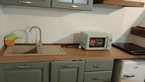 A kitchen with a sink, a microwave, and a small refrigerator. - Appartamento Olive La Burraia (GAMBASSI TERME)