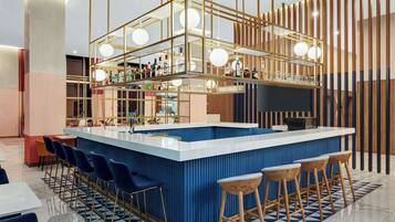 Un bar moderno con una barra azul, varios taburetes y una vitrina de vidrio.