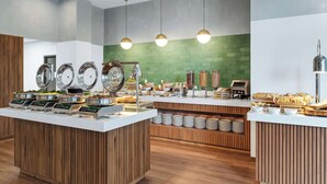 A buffet setup with multiple food stations, including a variety of dishes and beverages. - Hilton Garden Inn San Jose Airport City Mall (Alajuela)