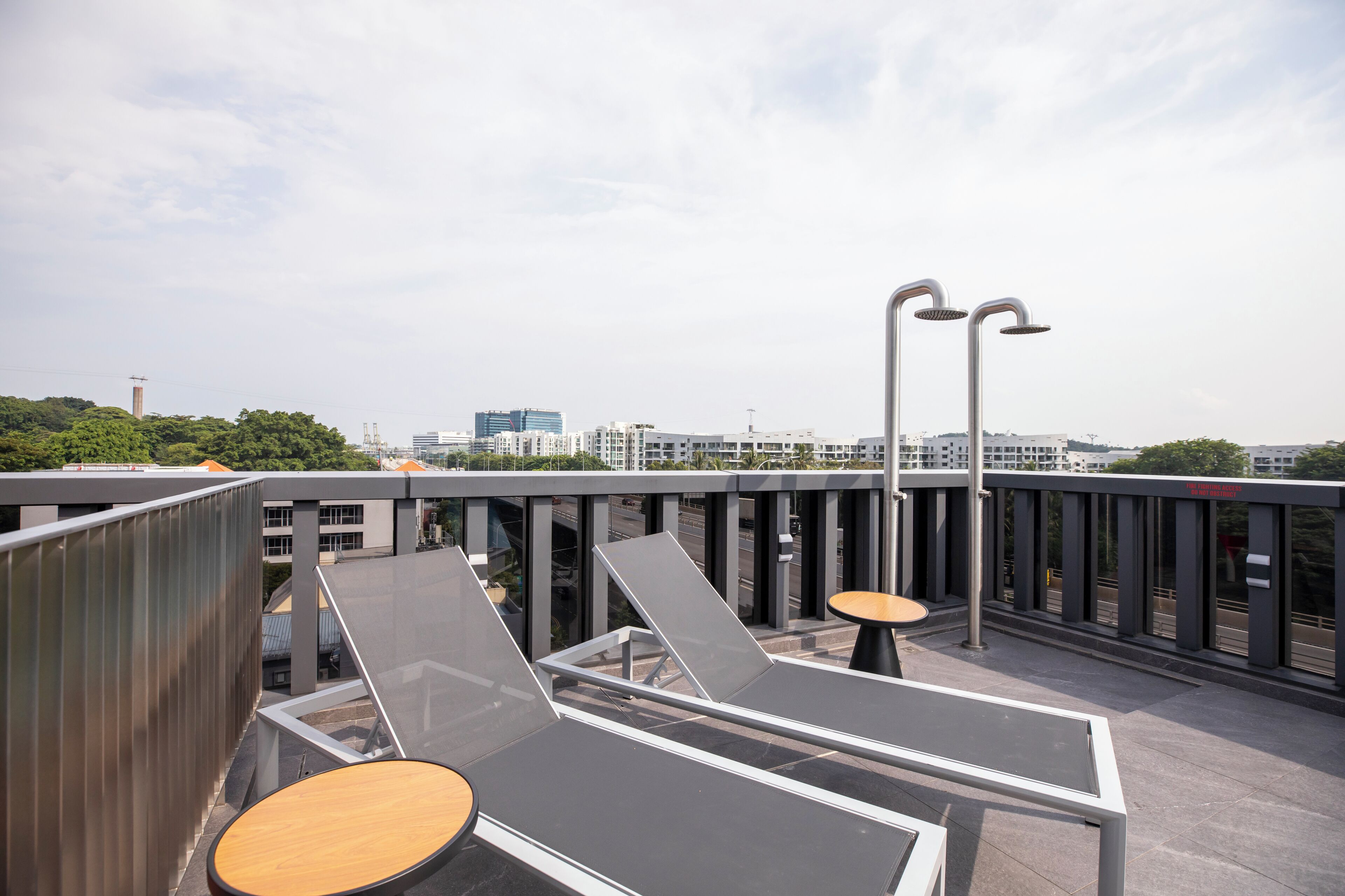 Een terras op het dak met modern meubilair en uitzicht op de skyline van de stad.