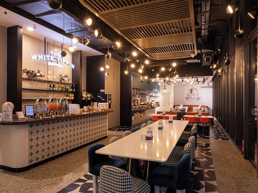 Een restaurant met een bar, zitplaatsen en een vloer met een patroon.