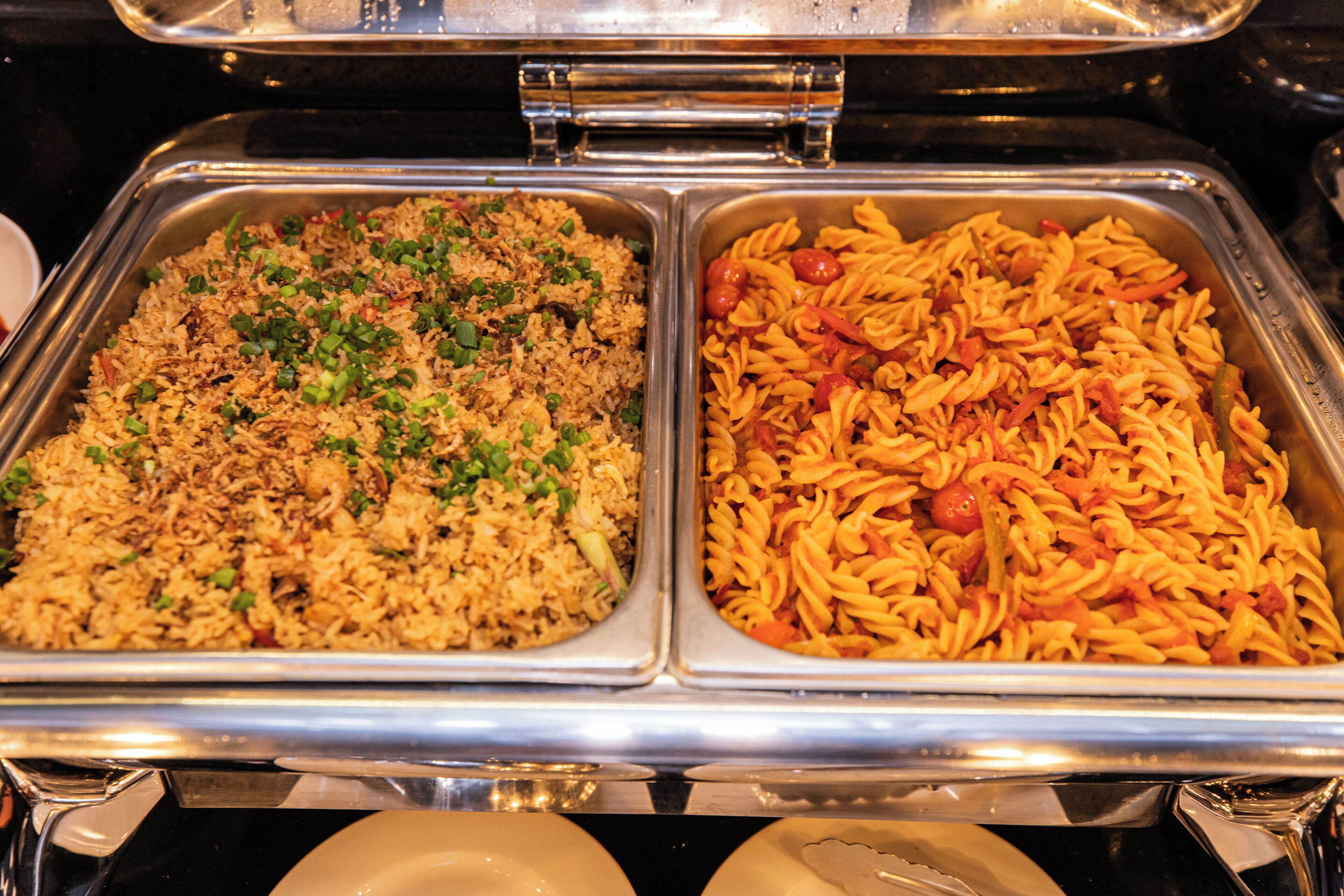 En buffet med to afsnit: et med stegt ris og et andet med pasta.