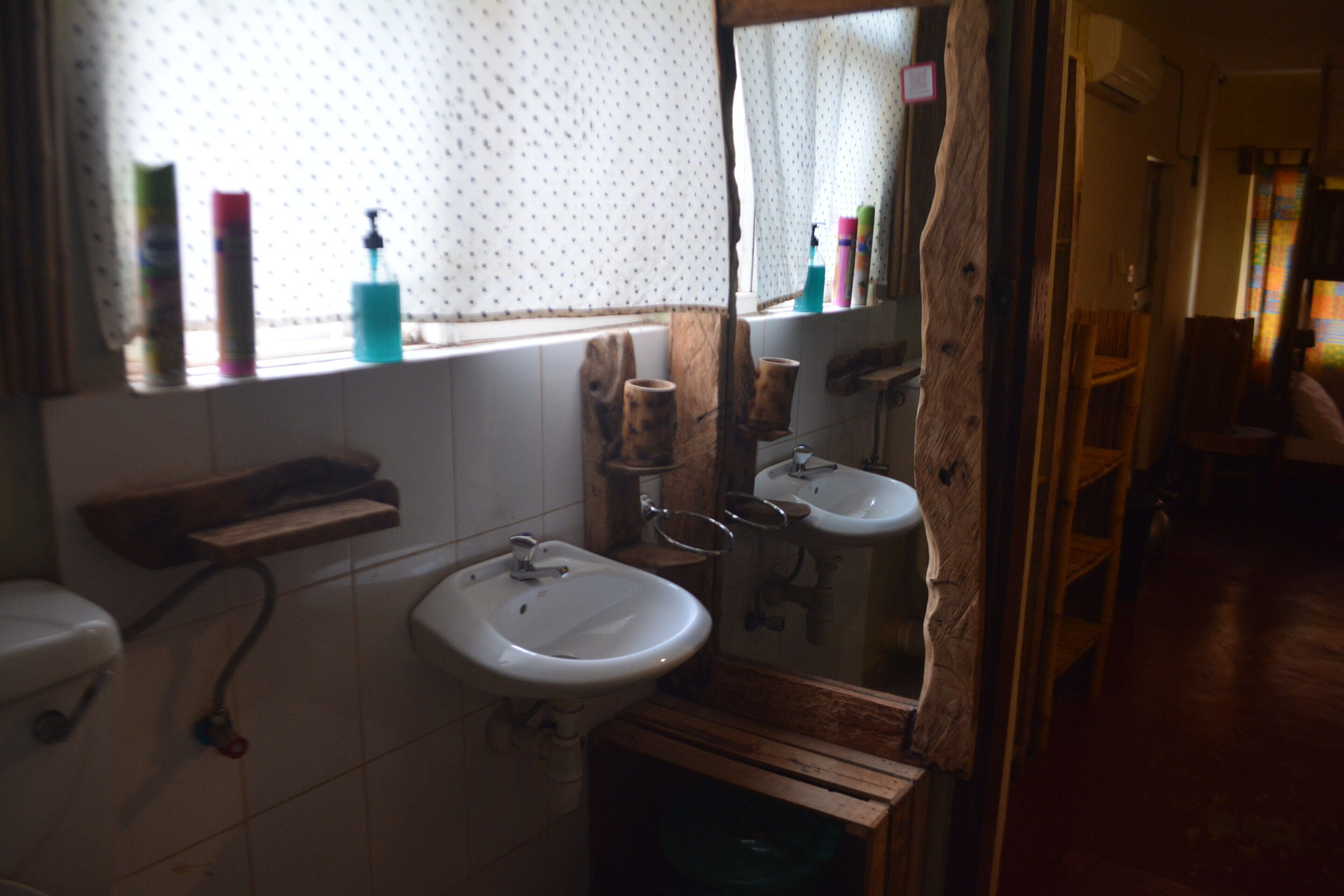 A bathroom with a wooden vanity, two sinks, and a mirror.
