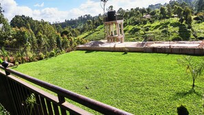A grassy area with a small structure and a fence. - Eliper Hotel (Gatura)