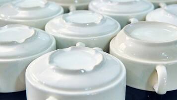 A collection of white ceramic teapots with lids, arranged on a black surface.