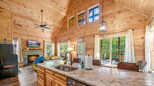 A spacious cabin interior with a large kitchen, dining area, and a fireplace. - Cozy cabin minutes from restaurants & entertainment and surrounded by nature.   (Sevierville)