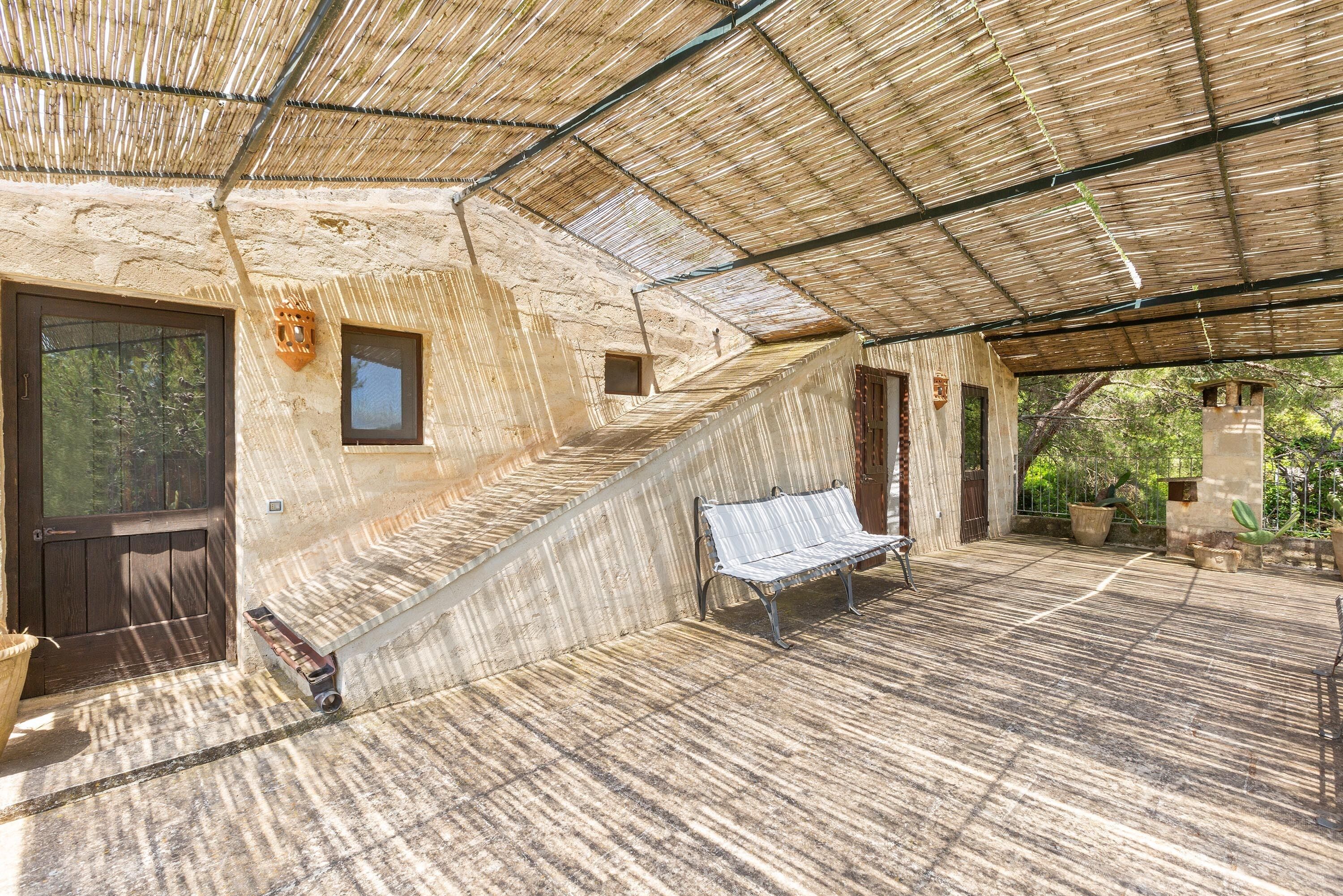 A covered outdoor area with a bench, a door, and a small window.