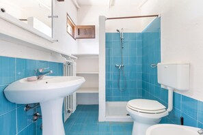 A bathroom with a white sink, a toilet, and a shower area with blue tiles. - 3502 PJE - Casa Pappagalli by Barbarhouse (Castrignano del Capo)