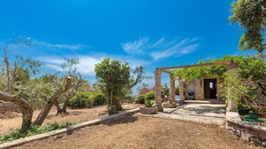 A rustic outdoor area with a pergola, stone pathway, and a small building with a door. - 3503 PJE - Casa La Pergola by Barbarhouse (Castrignano del Capo)