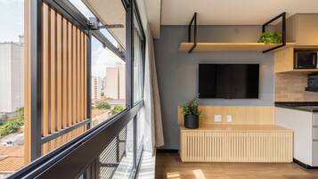 Une cuisine moderne avec un banc en bois, un téléviseur à écran plat et une plante en pot.