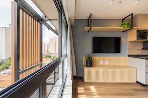 A modern kitchen with a wooden bench, a flat-screen TV, and a potted plant. - B.Homy - VA Perdizes (São Paulo)