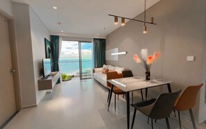 Enjoy a serene sea view from the large balcony, relax in the seating area with a sofa and TV, or dine at the table and chairs.