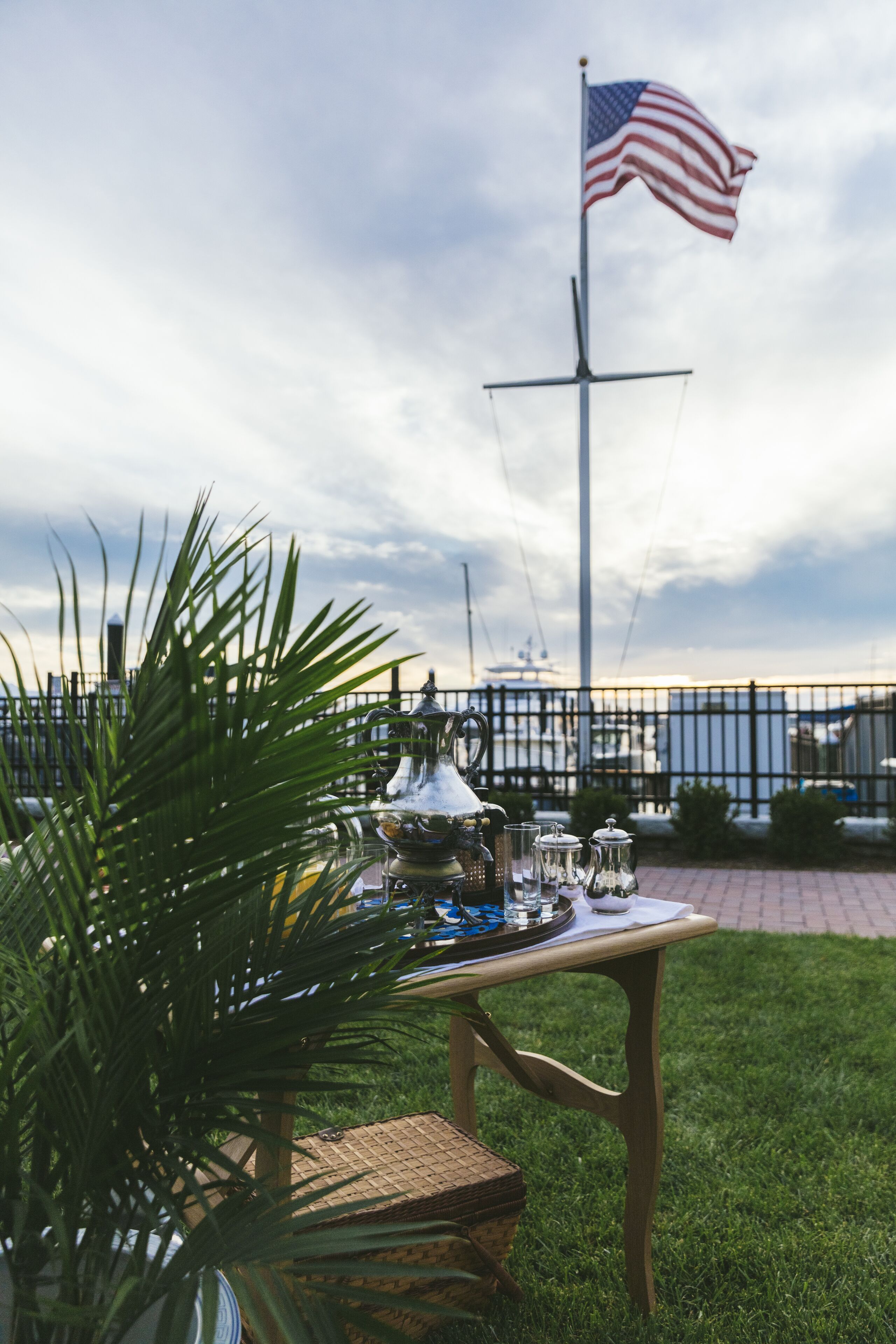 Una mesa con una bandera, una fuente y vistas a barcos y un puerto deportivo.