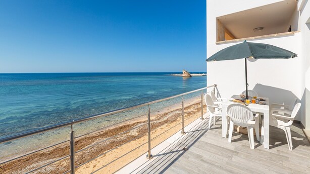 A balcony with a table and chairs overlooking a beach. - 3386 Un Sogno sul Mare by Barbarhouse (Salve)