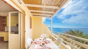 Un balcón con una mesa para dos, con vista al mar.
