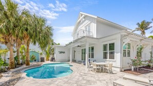 A white house with a pool, outdoor furniture, and palm trees. - Located in Captiva Village! Beautifully Designed Pool Home (Captiva)