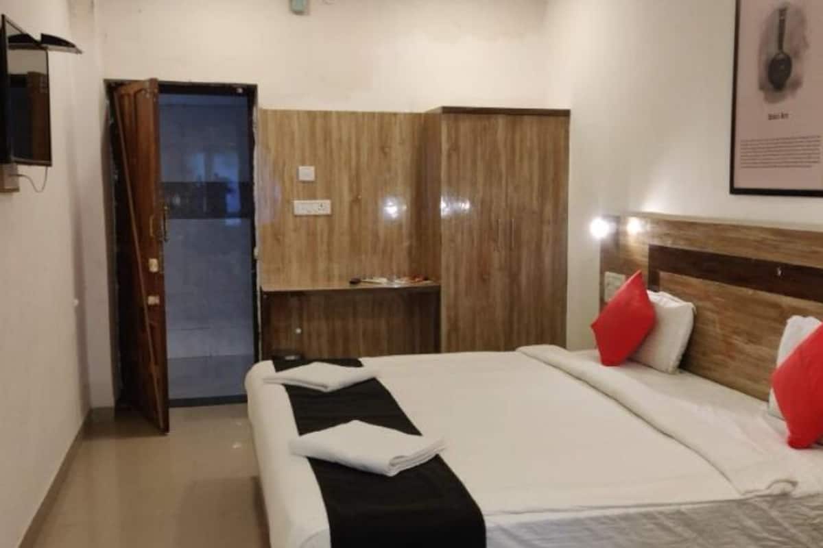 Une chambre d’hôtel comprenant un lit, une armoire, un bureau et un téléviseur.