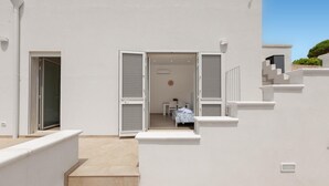 A modern building with a staircase leading to a room with a bed and a small table. - 3545 Antonio - App Pulcinella by Barbarhouse (Castrignano del Capo)