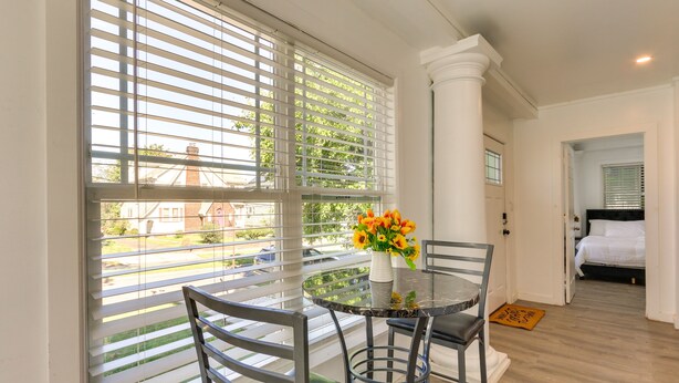 A dining area with a round table, chairs, and a vase of flowers. - Chic Newark Vacation Rental: 3 Mi to Airport! (Newark)