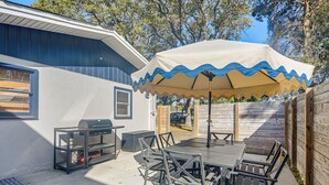A patio with a table and chairs, a grill, and a covered umbrella. - 2 Blocks to Sand! Breezy Atlantic Beach Escape (Myrtle Beach)