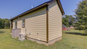 A single-story house with a beige siding exterior, a brown roof, and a small attached garage.