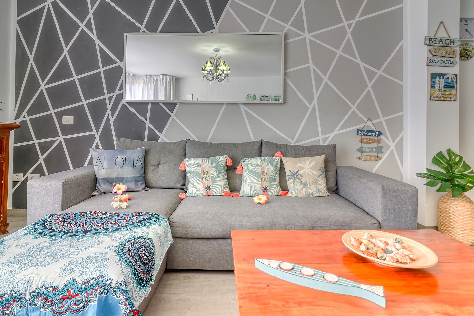 Een moderne woonkamer met een grijze bank, een gebreid plaid en een houten salontafel met een decoratief object.
