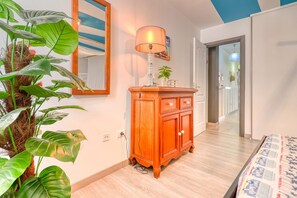 A room with a wooden cabinet, a mirror, and a potted plant.