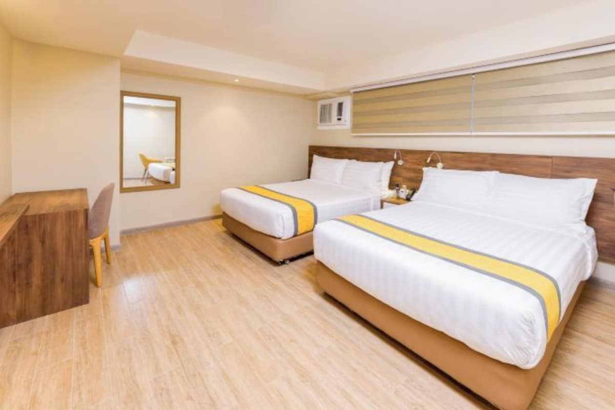 Een hotelkamer met twee bedden, een bureau en een spiegel.