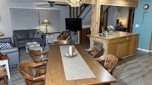 A dining area with a wooden table, chairs, and a central decorative piece. - Steps to Lake Erie near Lakeside & Port Clinton - Private Hot Tub & Recreation (Lakeside Marblehead)