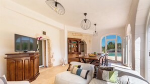 A spacious living area with a television, wooden cabinet, and comfortable seating. - 3483 Casale Amenola by Perle di Puglia (Ostuni)