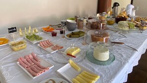 Una mesa de buffet con diversos alimentos, incluyendo carnes, quesos y frutas.