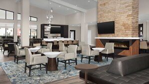 Un hall d’entrée spacieux avec une cheminée, des sièges confortables et un coin bar.