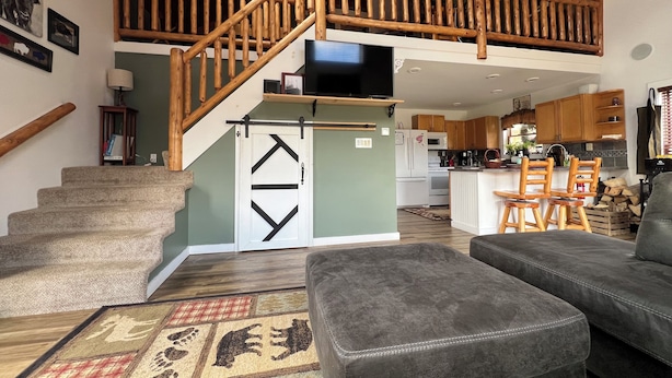 A spacious living area with a loft bedroom, a staircase, and a kitchen.