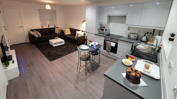 Eine moderne Wohnung mit Wohnbereich, Küche und Essbereich.