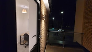 Ein modernes Hotelzimmer mit großem Fenster, Schreibtisch und Stuhl.