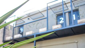 A building with a garage door and a number '2' sign. - Suites Isla Verde (La Rioja)