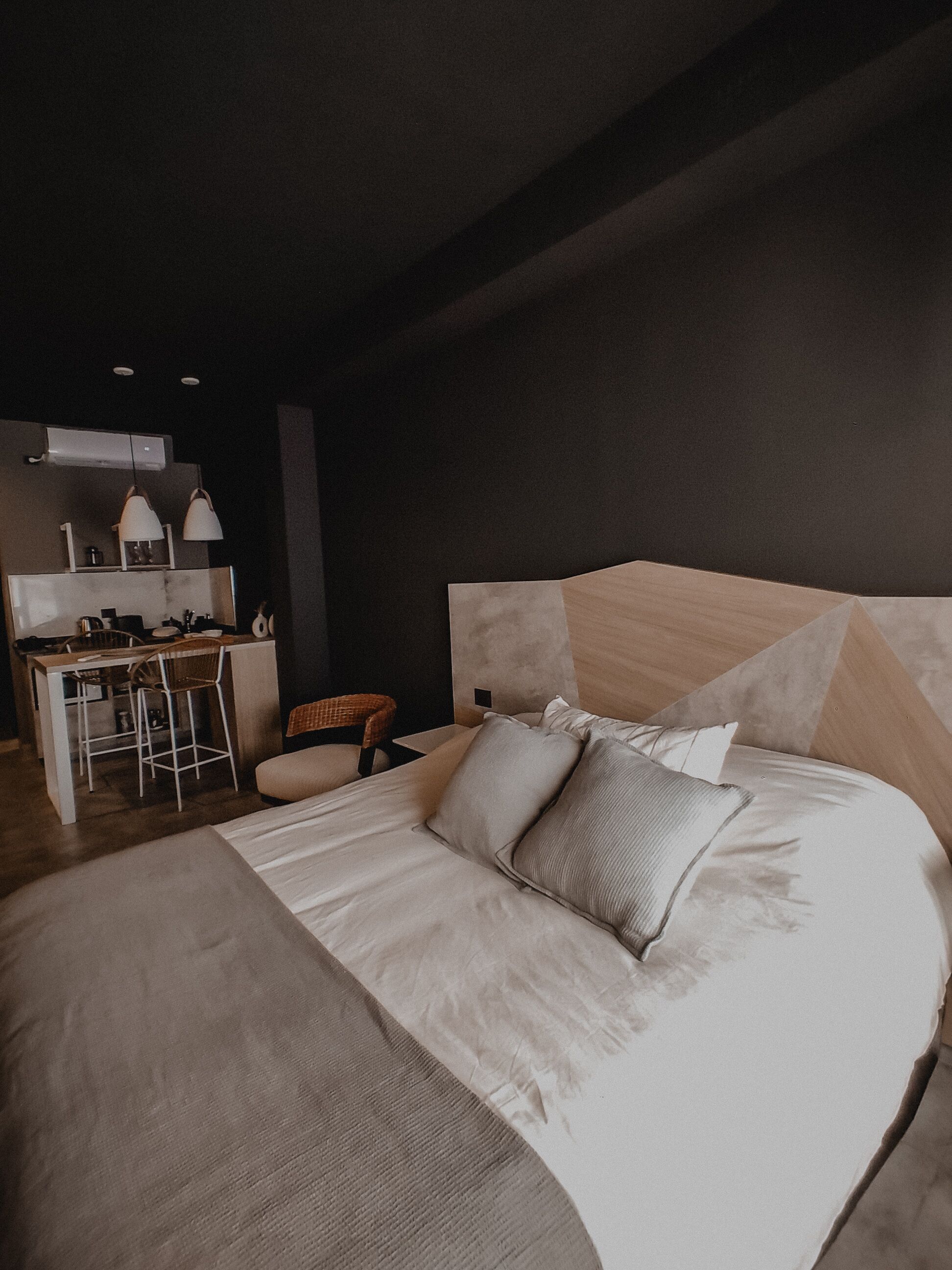 A modern bedroom with a large bed, a desk, and a chair.