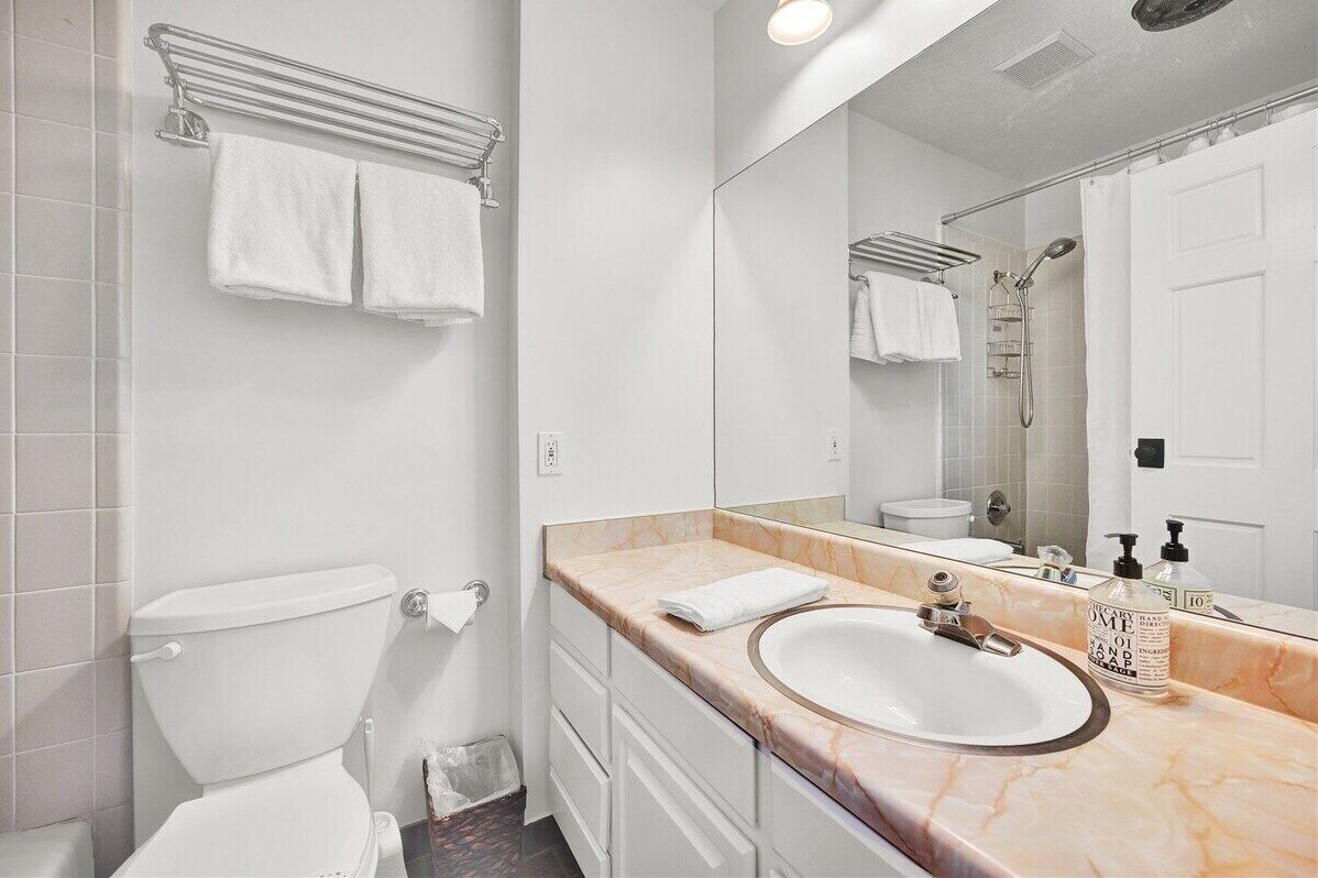 Une salle de bain moderne avec des toilettes, un lavabo et un miroir.