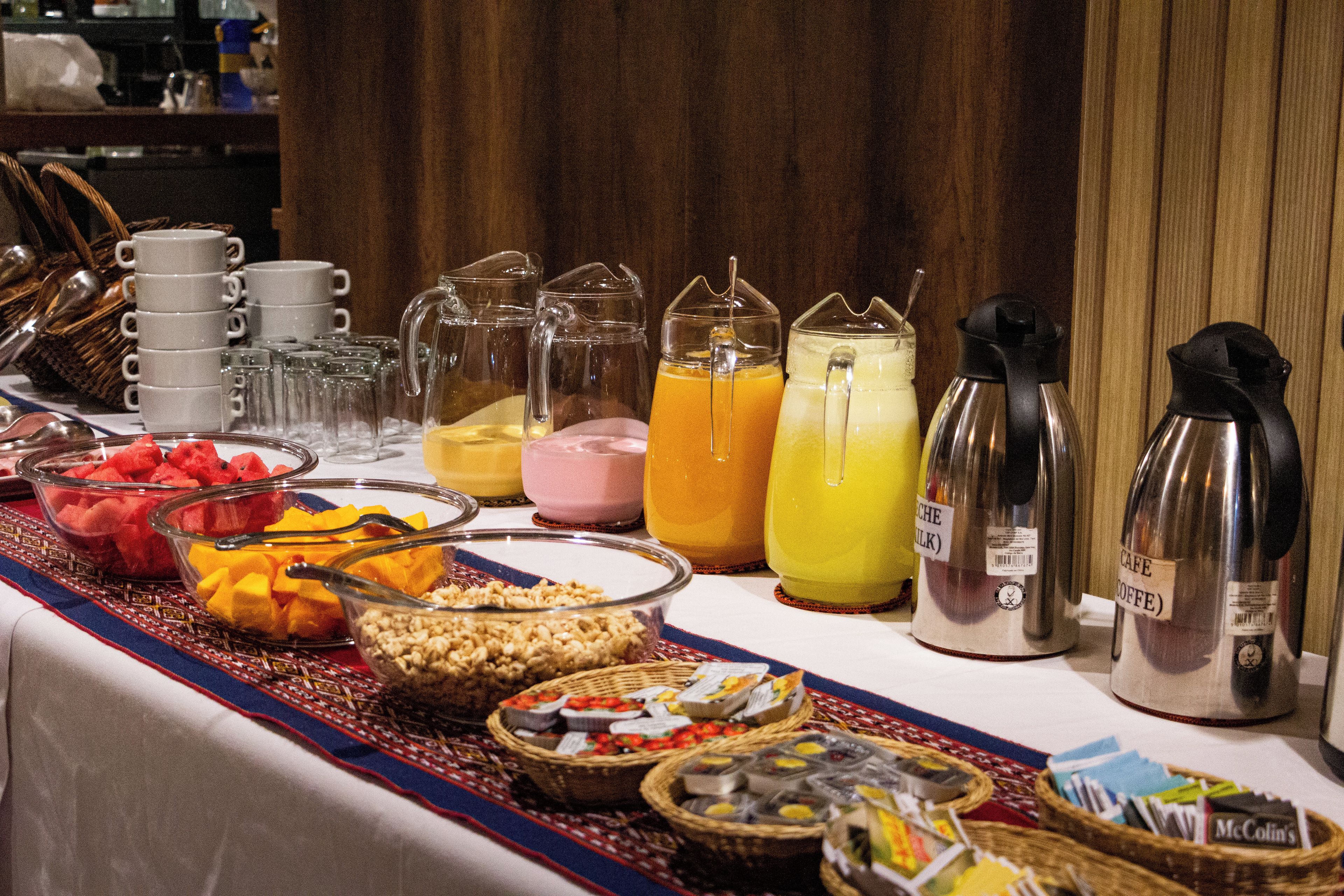 Une table de buffet proposant une variété de plats, de boissons et un coin café.
