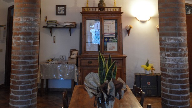 A dining area with a wooden table, brick columns, and a brick ceiling. - La Fraschetta (Bolsena)
