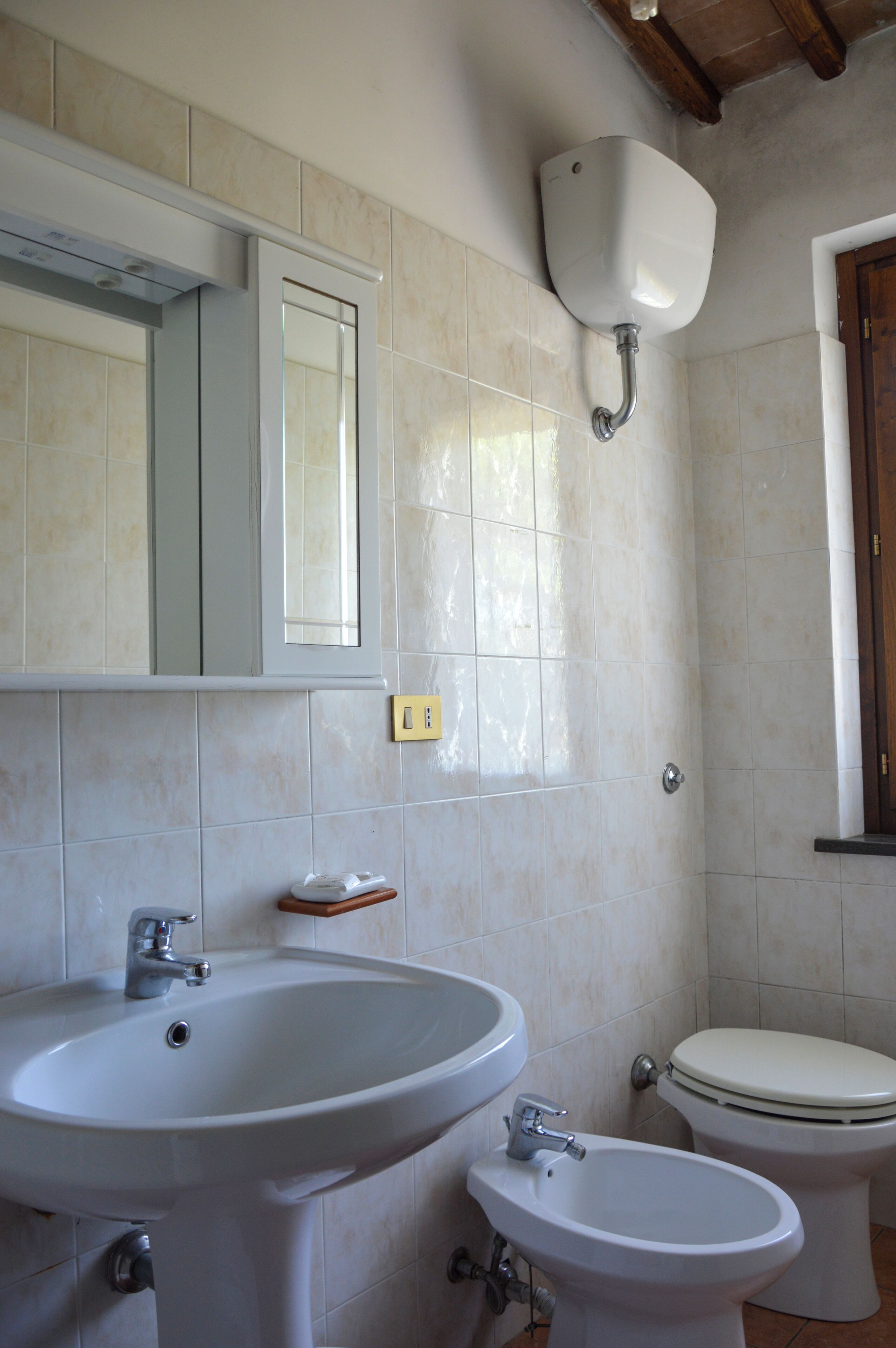 Un bagno con lavandino, bidet, WC e specchio.