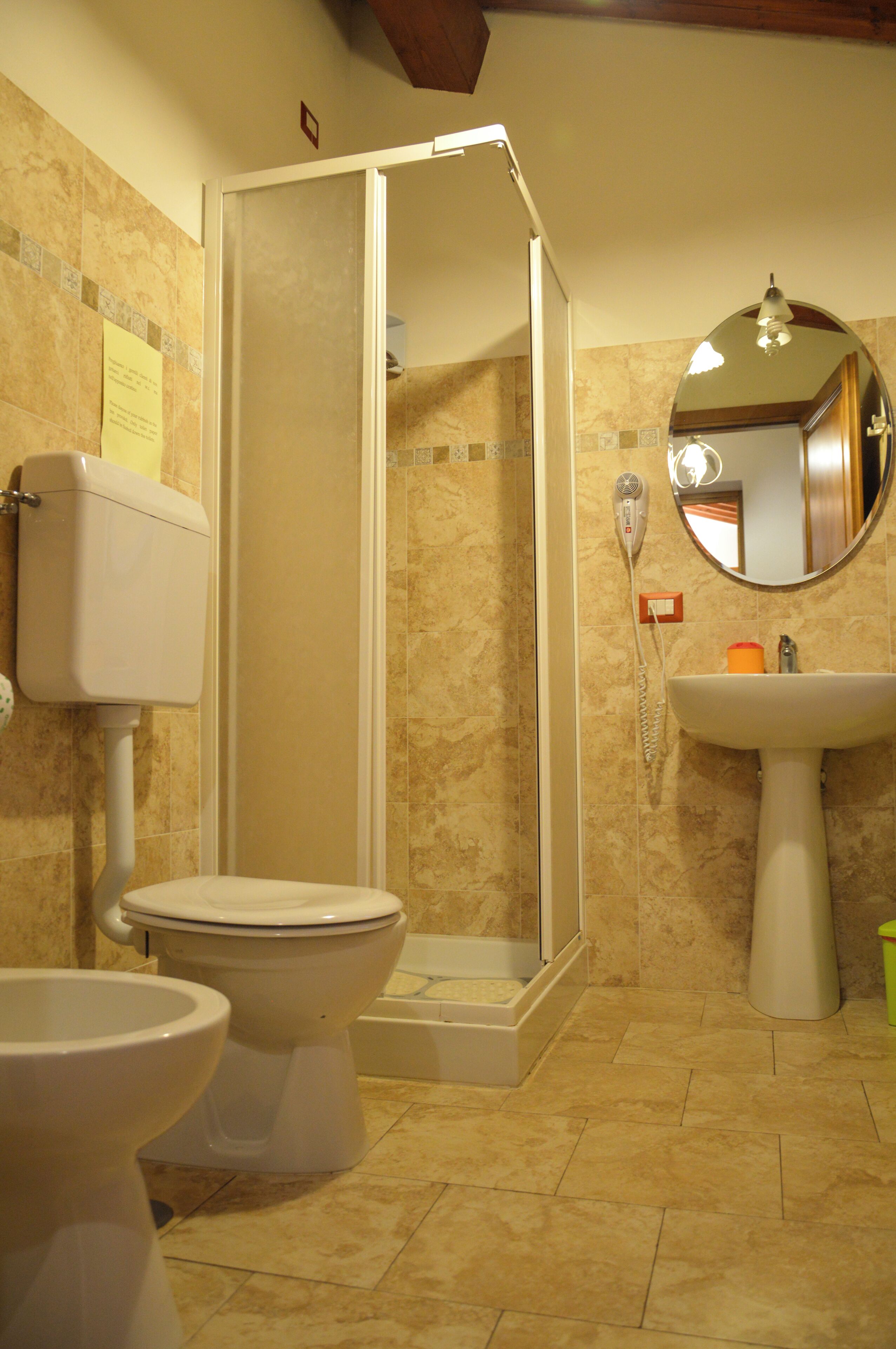 A bathroom with a toilet, a sink, and a shower stall.