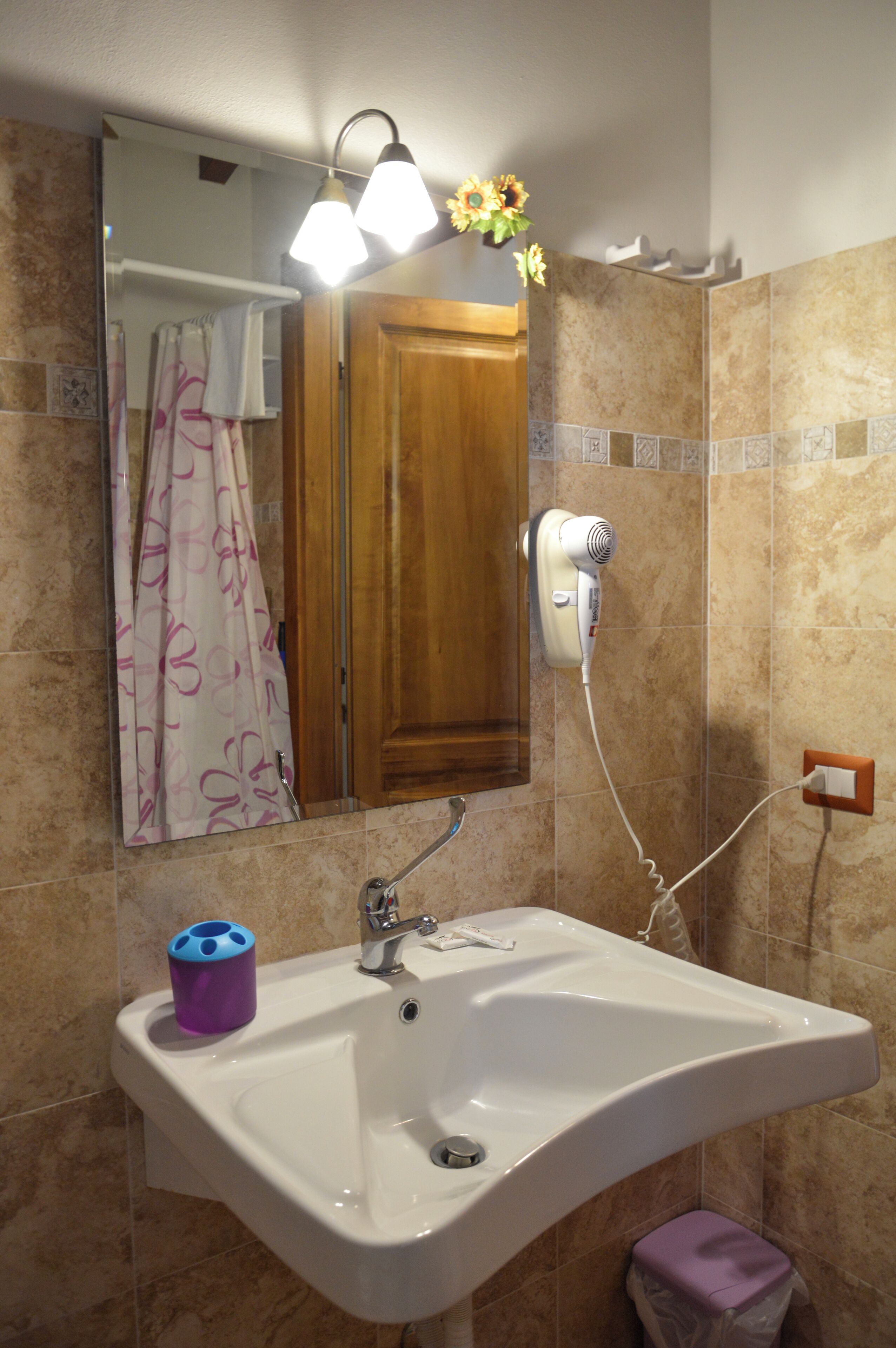 A bathroom with a sink, mirror, towel rack, and a hairdryer.