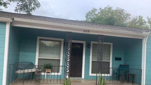 A teal house with the number 809, a front porch with steps, two potted plants, and a small garden area. - 3 blocks from AT&T Stadium 2 bedroom-sleeps 6 (Arlington)