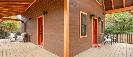 A wooden cabin with a deck, two doors, and windows.
