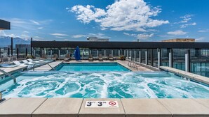 A rooftop pool with clear blue water, lounge chairs, and a glass barrier. - Gorgeous Downtown 1BD/1BA - BEST views + Amenities (Salt Lake City)