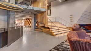 Ein modernes Interieur mit Treppe, Holzvertäfelung und Sitzecke.